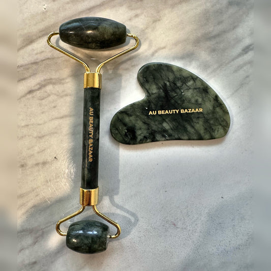 AU Beauty Bazaar green jade roller and heart-shaped gua sha on marble