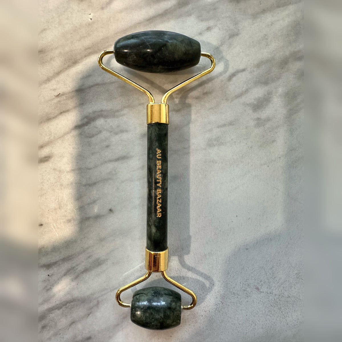 AU Beauty Bazaar green jade face roller with gold frame and engraved handle